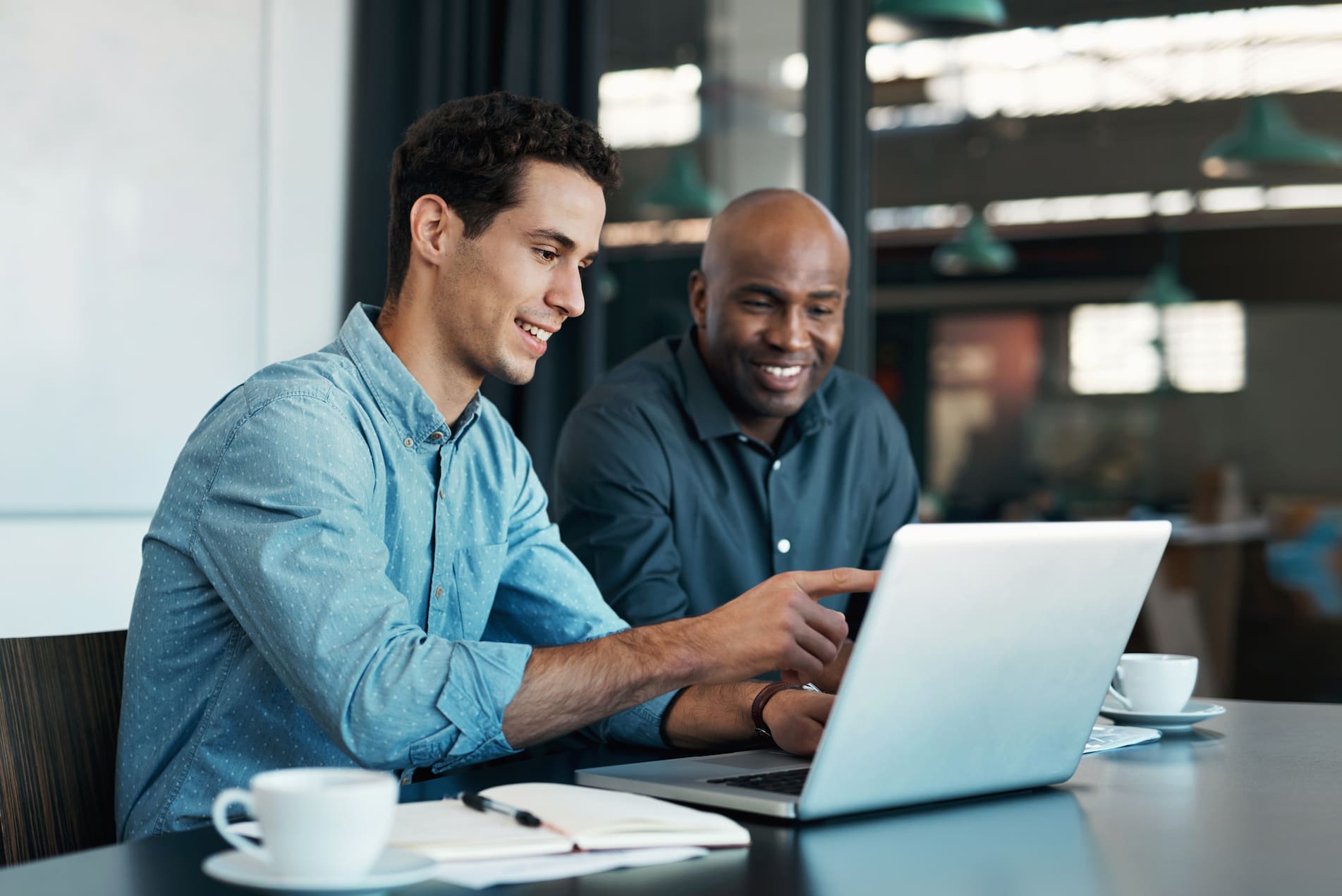 coworkers in discussion and looking at laptop monitor