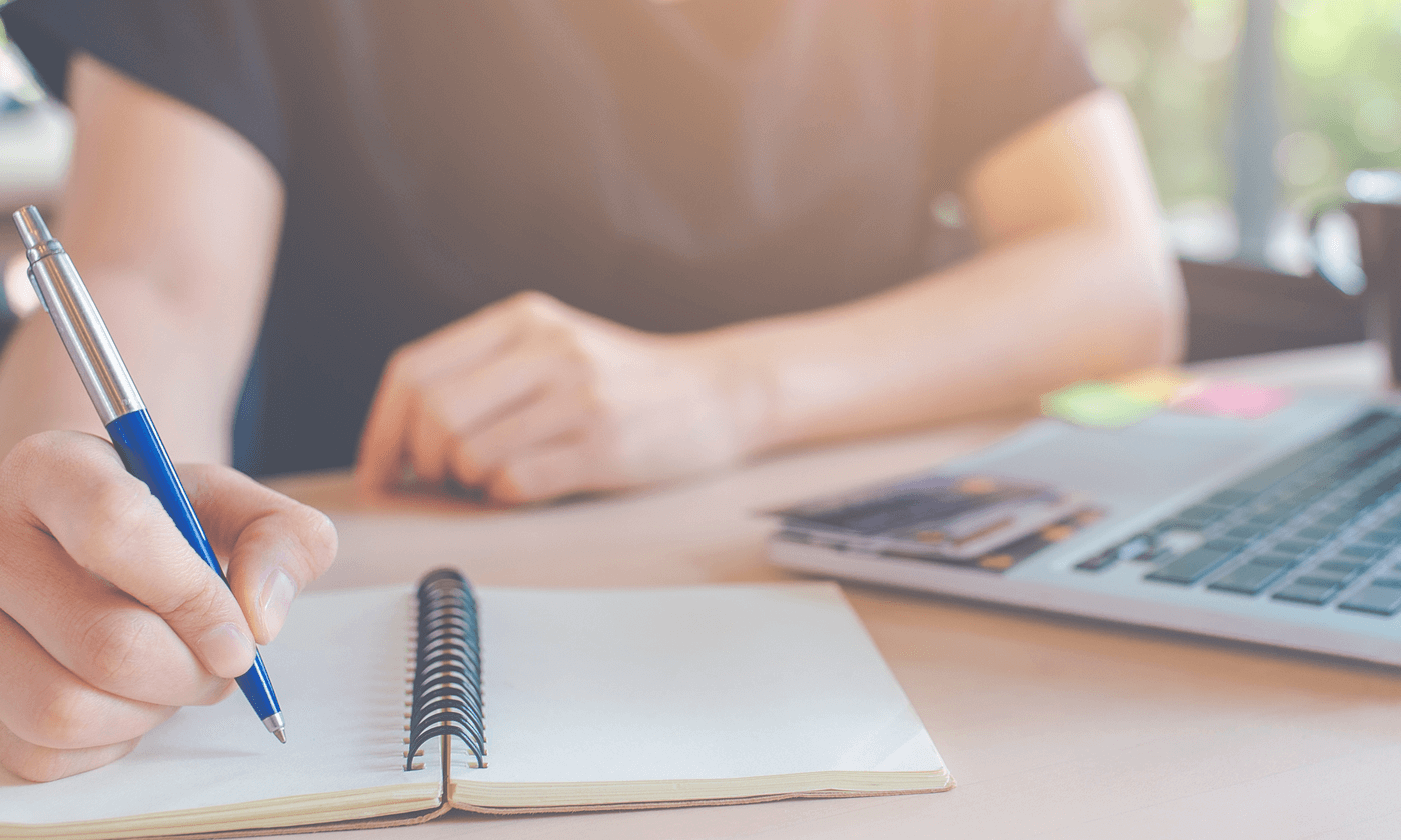 person writing on a notebook