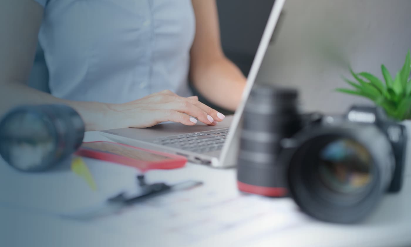 woman working on laptop with lens in the background