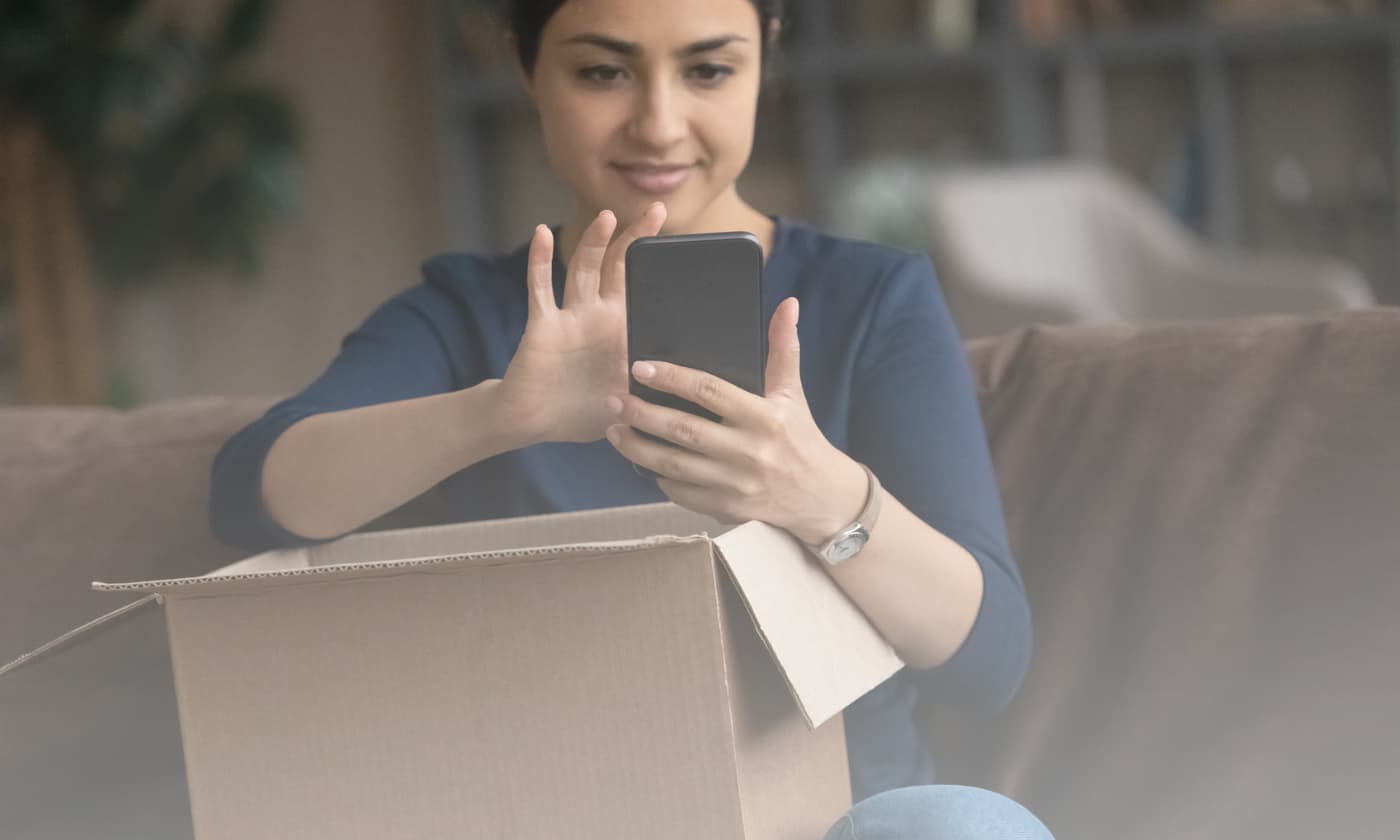 woman holding a box and smartphone