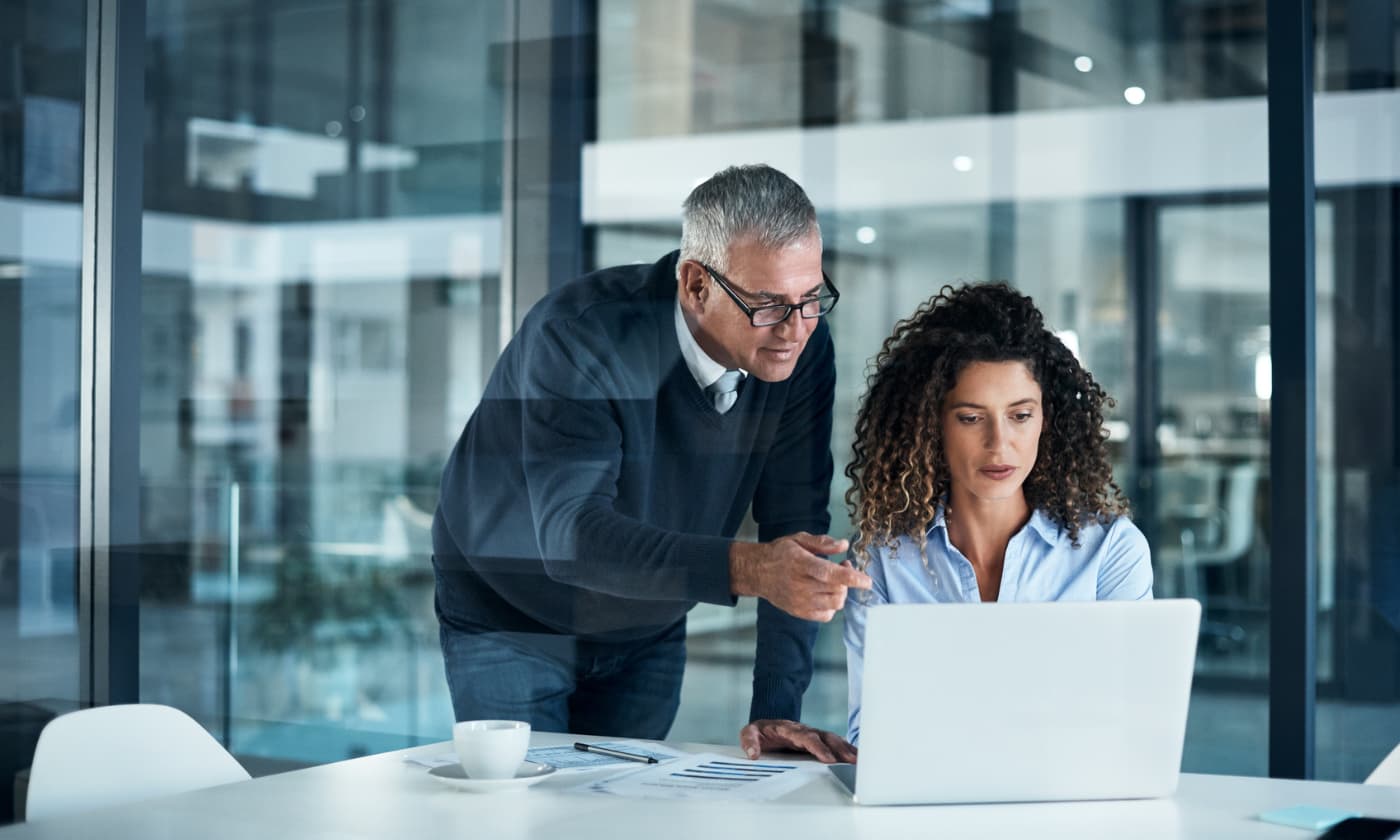 businesspeople working on laptop in office setting