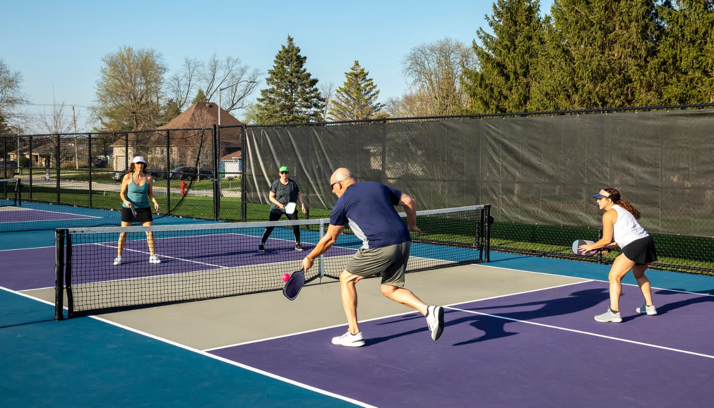 Four people playing pickleball