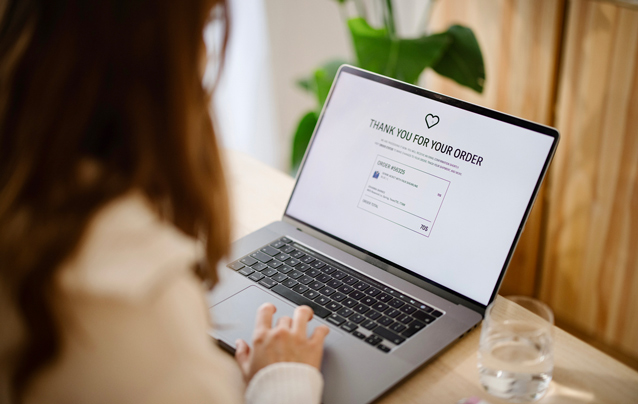 woman using laptop showing order ecommerce completion page