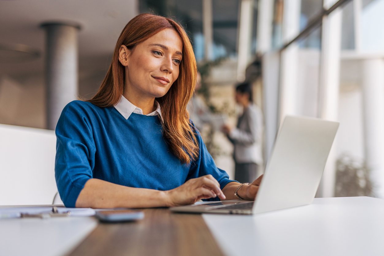 A successful businesswoman is using a laptop and working in the office stock photo
